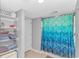 The bathroom has an open shelving with towels, shower and a toilet at 2151 Bridge View Ct. # 1-803, North Myrtle Beach, SC 29582