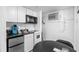 A kitchenette with white appliances and cabinets, a sink and black table with chairs is shown at 2600 S Ocean Blvd. # 215, Myrtle Beach, SC 29577