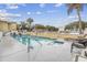 Refreshing in-ground rectangular pool featuring poolside seating and a security fence with swaying palm trees under a cloudy sky at 2600 S Ocean Blvd. # 215, Myrtle Beach, SC 29577