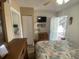Bedroom featuring seashell themed bedding, TV, and entrance to small kitchenette in the background at 2708 S South Ocean Blvd. # 102, Myrtle Beach, SC 29577