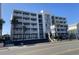 Charming multi-story building with white facade, balconies, palm trees, and well-maintained landscaping at 2708 S South Ocean Blvd. # 102, Myrtle Beach, SC 29577