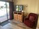 Comfortable living space with a flat-screen TV, wooden dresser, and plush red chair at 2708 S South Ocean Blvd. # 102, Myrtle Beach, SC 29577