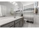 Well-lit bathroom featuring a single sink vanity, tiled floors, and a shower with a striped curtain at 30 Baldwin Loop, Pawleys Island, SC 29585