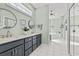 Bright bathroom featuring a dual sink vanity, white tile flooring, and a separate tub and shower at 30 Baldwin Loop, Pawleys Island, SC 29585