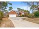 Charming brick home featuring a well-manicured lawn and an extended driveway leading to an attached two-car garage at 30 Baldwin Loop, Pawleys Island, SC 29585