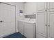Bright laundry room featuring a white washer and dryer, white cabinets and a door at 30 Baldwin Loop, Pawleys Island, SC 29585
