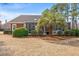 Back of brick home showcasing screened porch surrounded by well maintained landscaping at 30 Baldwin Loop, Pawleys Island, SC 29585