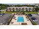Aerial view of a condo complex and in-ground pool with lounge chairs and fenced-in area at 405 21St Ave. S # 1-O, North Myrtle Beach, SC 29582