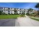 Well-maintained condo complex with manicured lawn, shrubbery, walkway, and mature palm trees at 405 21St Ave. S # 1-O, North Myrtle Beach, SC 29582