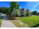 Well maintained condo building with mature landscaping, green lawn, and sidewalk access at 405 21St Ave. S # 1-O, North Myrtle Beach, SC 29582