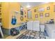 Laundry room featuring yellow walls, washer and dryer, ironing board, and decor at 413 30Th Ave. N, Myrtle Beach, SC 29577