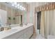 Bright bathroom featuring double sinks, a shower, and a vanity with a large mirror at 4306 Windy Heights Dr., North Myrtle Beach, SC 29582