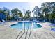 Inviting community pool area surrounded by lounge chairs and mature trees at 4717 Cobblestone Ln. # B3, Myrtle Beach, SC 29577