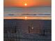 Sunrise reflecting off of a tranquil ocean with a sand fence in the foreground at 4717 Cobblestone Ln. # B3, Myrtle Beach, SC 29577