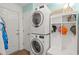 Well-lit laundry room with a stacked washer and dryer next to a hall tree and white door at 4856 Bermuda Way N, Myrtle Beach, SC 29577