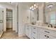 Bright bathroom featuring double vanity sinks, a walk-in closet, and modern light fixtures at 4934 Salt Creek Ct., North Myrtle Beach, SC 29582