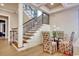 Inviting entryway with a staircase featuring wrought iron spindles and a dining table with colorful chairs at 4934 Salt Creek Ct., North Myrtle Beach, SC 29582