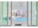 View of sparkling pool and resort through sliding glass doors from covered veranda with ceiling fans at 4934 Salt Creek Ct., North Myrtle Beach, SC 29582