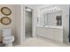 Bright bathroom featuring a large vanity with a mirror, a toilet, and a walk-in closet at 5077 Capulet Circle, Myrtle Beach, SC 29588