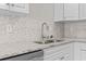Bright kitchen featuring stainless steel sink, granite countertops, and a mosaic tile backsplash at 5077 Capulet Circle, Myrtle Beach, SC 29588