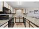 Modern kitchen featuring granite countertops, white cabinets, and black appliances at 510 Fairwood Lakes Ln. # 20E, Myrtle Beach, SC 29588