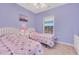 Bright bedroom with two twin beds, a window and simple lavender design elements at 5825 Catalina Dr. # 531, North Myrtle Beach, SC 29582