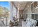 Inviting covered patio with comfortable seating, ceiling fan, and scenic views of lush greenery and water at 5834 Longwood Dr. # 303, Murrells Inlet, SC 29576