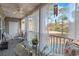 Relaxing covered patio featuring cozy seating, ceiling fan, and serene views of the outdoors and a windchime at 5834 Longwood Dr. # 303, Murrells Inlet, SC 29576