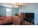 A bright bedroom featuring a ceiling fan and a large window with plantation shutters at 5865 Creekside Dr., Myrtle Beach, SC 29588