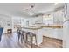 Bright kitchen features white cabinetry, matching appliances, a kitchen island with barstool seating, and updated lighting at 6001-N50 S Kings Hwy., Myrtle Beach, SC 29575