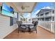Inviting covered patio with wood table, seating for four, ceiling fan, and wall mounted TV at 6001-N50 S Kings Hwy., Myrtle Beach, SC 29575