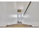 Stairwell with wood handrail, white walls, and a decorative sign leading down to the lower level at 6001-N50 S Kings Hwy., Myrtle Beach, SC 29575