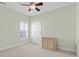 Neutral bedroom with a ceiling fan, window with shutter, and a small wood cabinet at 606 5Th Ave. S, North Myrtle Beach, SC 29582