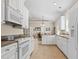 Well-lit open kitchen featuring white cabinets, tile floors, connecting to the dining and outdoor spaces at 606 5Th Ave. S, North Myrtle Beach, SC 29582