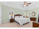 This main bedroom is illuminated by windows with shutters, a ceiling fan, and bedside lamps at 606 5Th Ave. S, North Myrtle Beach, SC 29582