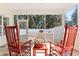 Charming screened porch with red rocking chairs, a small table, and tile flooring at 606 5Th Ave. S, North Myrtle Beach, SC 29582