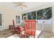 Relaxing screened porch with ceiling fan, tile flooring, and cozy red rocking chairs at 606 5Th Ave. S, North Myrtle Beach, SC 29582
