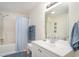 Bright bathroom featuring shower-tub combo with blue shower curtain and white vanity with sink at 613 Calhoun Dr., Murrells Inlet, SC 29576