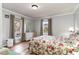 Bright bedroom with wood-paneled walls, floral bedding, and two windows bringing in natural light at 613 Calhoun Dr., Murrells Inlet, SC 29576