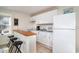 Eat-in kitchen featuring white cabinets, appliances, and bar seating at 613 Calhoun Dr., Murrells Inlet, SC 29576