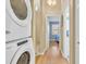 Hallway view, featuring a stacked washer and dryer and leading to sunlit bedroom with blue walls at 614 15Th Ave. S # 42, Surfside Beach, SC 29575