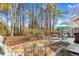 Serene backyard featuring mature trees, a patio dining set, and peaceful atmosphere at 6634 Cinnamon Fern Ln., Myrtle Beach, SC 29588