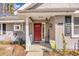 Inviting front porch featuring a red door and homey decorations and a covered entry way at 6634 Cinnamon Fern Ln., Myrtle Beach, SC 29588