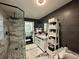 Modern bathroom with dark walls, a white vanity, glass shower and a view into the bedroom at 6636 Breezewood Blvd., Myrtle Beach, SC 29588