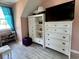 Upstairs bedroom with pink walls, white trim, a large dresser, and a window at 6636 Breezewood Blvd., Myrtle Beach, SC 29588