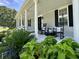 Inviting front porch featuring rocking chairs, white columns, and lush landscaping for relaxation at 6636 Breezewood Blvd., Myrtle Beach, SC 29588