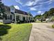 Charming single-Gathering home featuring a well-manicured lawn and welcoming front porch with classic columns at 6636 Breezewood Blvd., Myrtle Beach, SC 29588