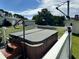 Inviting hot tub with steps and cover, set on a white fenced deck overlooking a grassy yard and lake at 6636 Breezewood Blvd., Myrtle Beach, SC 29588