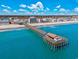 Aerial view of the pier extending over beautiful turquoise waters on a bright, sunny day at 919 Salt Pl., Murrells Inlet, SC 29576