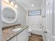Bright bathroom featuring a granite countertop, round mirror, and shower-tub combination at 919 Salt Pl., Murrells Inlet, SC 29576